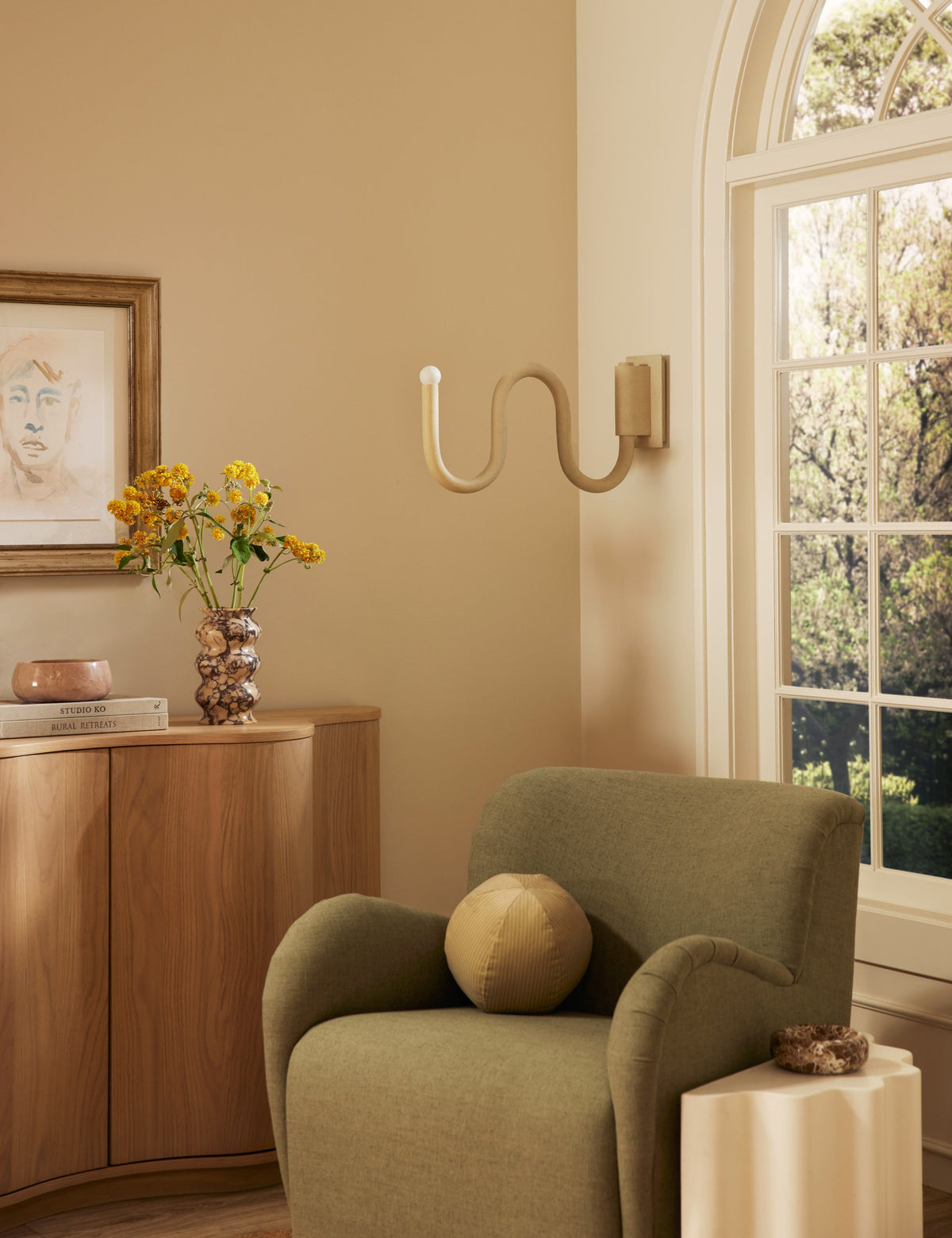 Noor Swing Arm Sconce bedroom wall light in a styled room